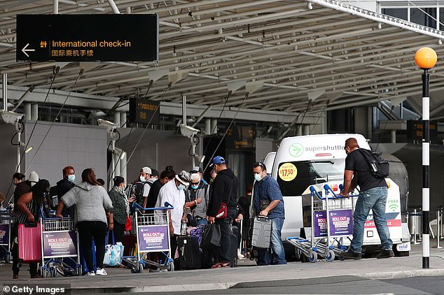 Pictured: Passengers wear protective masks and gloves at Auckland International Airport in April