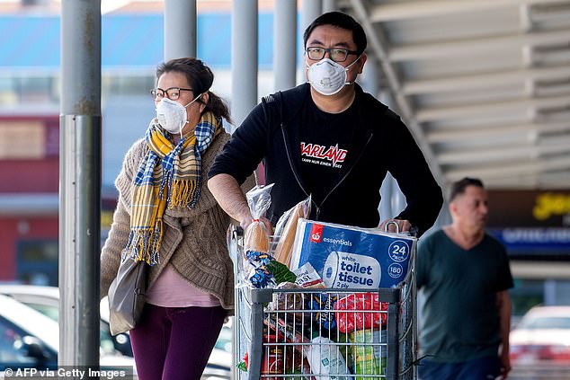 Residents in Wellington wear face masks on March 24 as they leave a supermarket after buying supplies one day before the country goes into lockdown